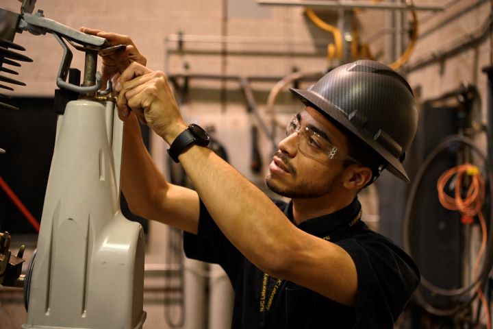 An S&C team member mounts a TripSaver II Cutout Mounted Recloser for testing