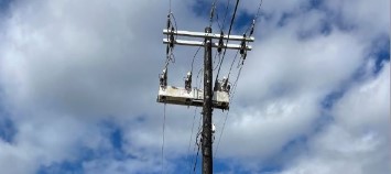 An IntelliRupter PulseCloser Fault Interrupter installed on a feeder with a clear blue sky in the background. 